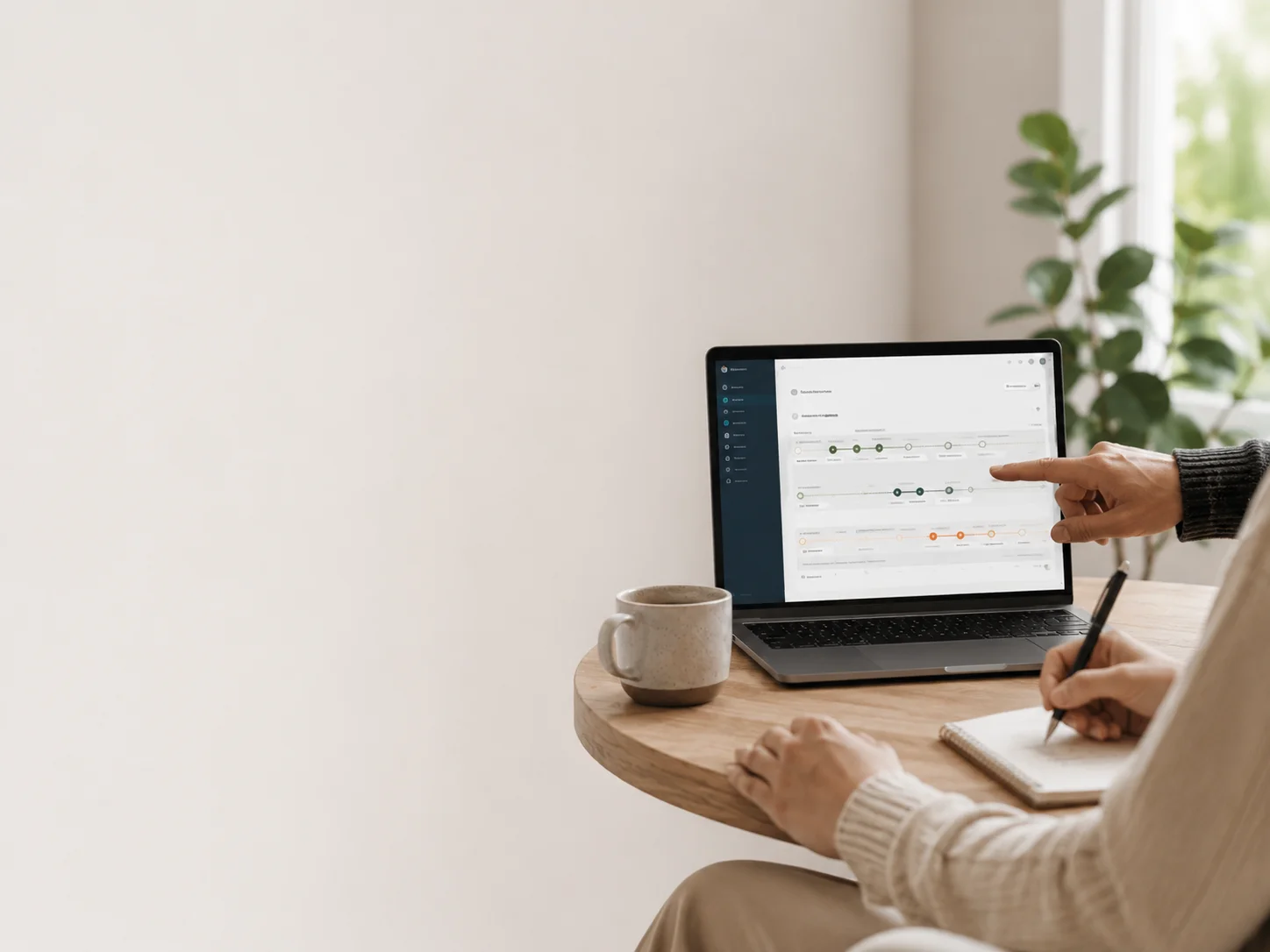Rolig samarbejdssituation med laptop, digital plan, kaffe og notesbog til rådgivning om hjemmeside